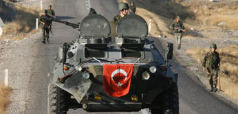 Turkish soldiers patrol and search for mines on a road surrounded by rugged mountains in south-eastern province of Sirnak
